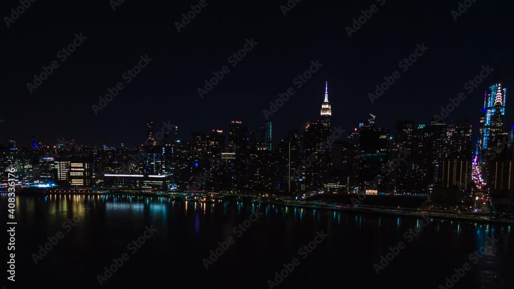 Moon hiding and rising behind the Skyscrapers' Silhouette, aerial loop of New York City at Night, with cars and lights moving in the streets. Moon hiding and rising behind the Skyscrapers' Silhouette, aerial loop of New York City at Night, with cars and lights moving in the streets.