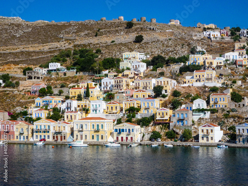 houses, buildings and castle with yachts and boats in the port town of Simi a Greek island in the Aegean