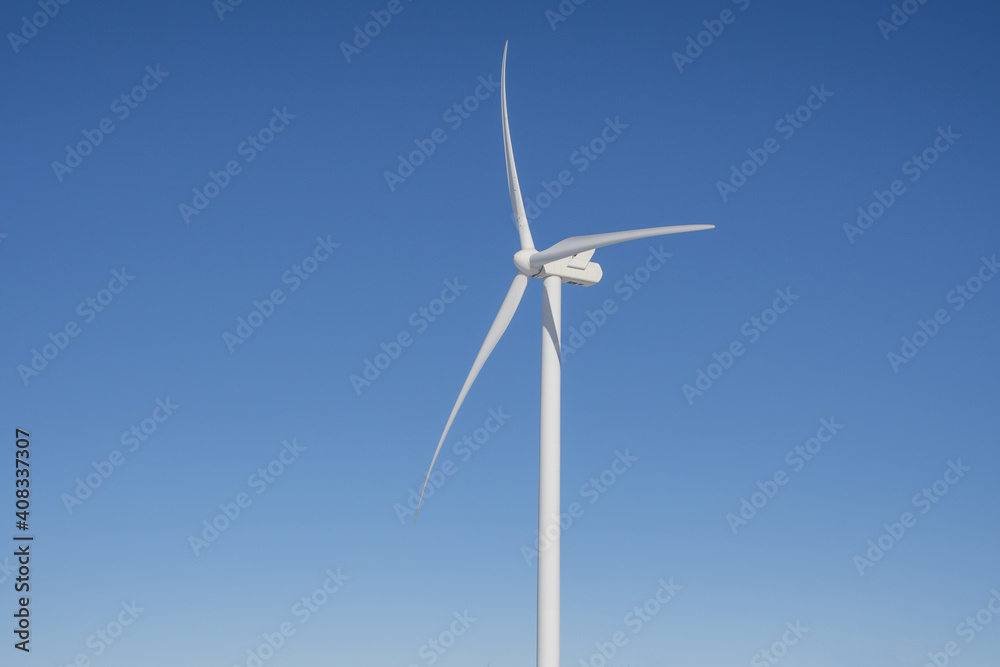 Close-up view of a wind turbine on a blue sky