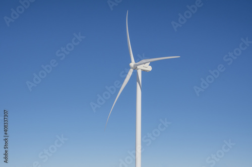 Close-up view of a wind turbine on a blue sky