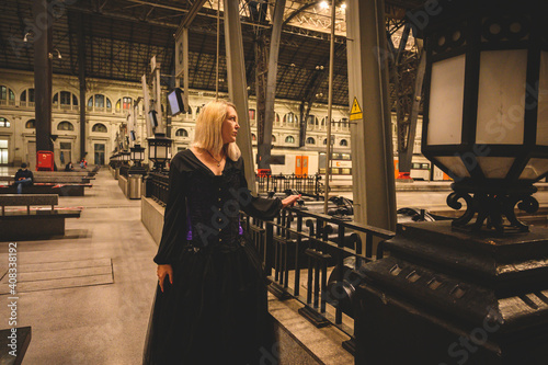 Mujer rubia con ropa vintage de color negro y falda pomposa en un espacio interior de arquitectura modernista photo