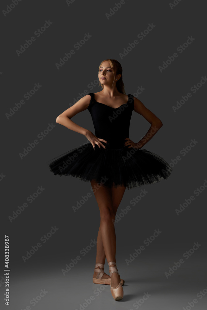 Young ballerina in black tutu and pointe shoes is dancing on studio background Young ballerina in black tutu and pointe shoes is dancing on studio background