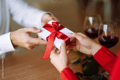 Exchange of gifts. Young couple in love offering gift to each other for valentine day or birthday. Romantic day. Winter holidays.