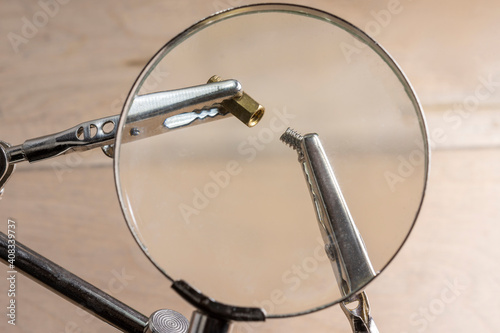 Computer screws under magnifying glass