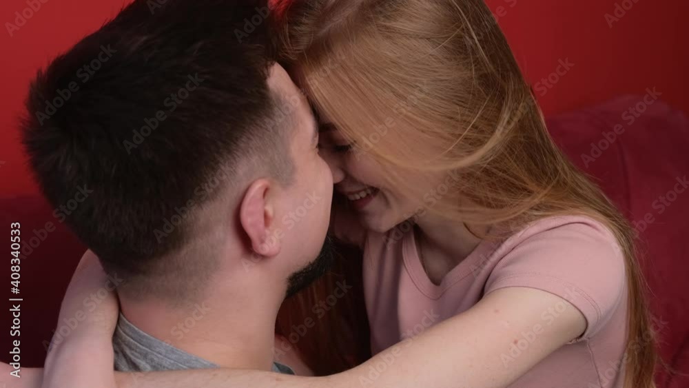 Ginger woman with freckles is embracing her lover while sitting on a couch relaxing on valentines day Ginger woman with freckles is embracing her lover while sitting on a couch relaxing on valentines day