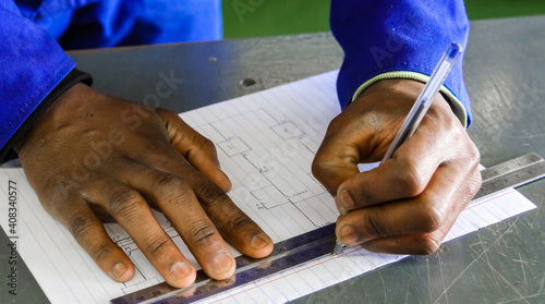Closeup of a man using a ruler on drawing an architectural map, vocational skills photo