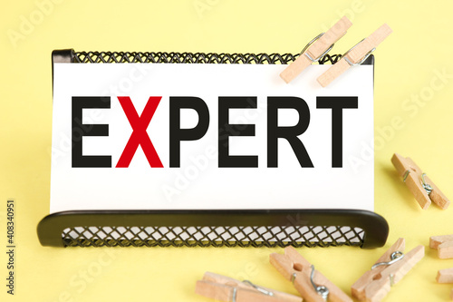 expert, text on white paper on yellow background. work table photo