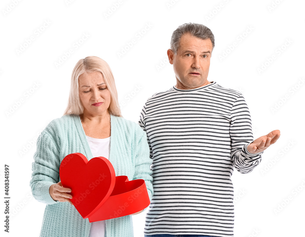Mature man greeting his displeased wife on Valentine's Day against white background