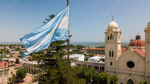 Argentinian flag waving in the wind against a blue sky, Victoria city, Entre Rios, Argentina photo