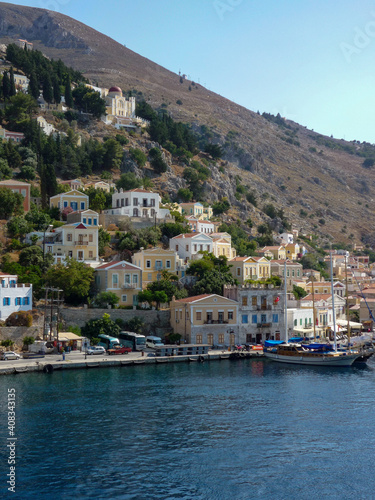 houses, buildings and castle with yachts and boats in the port town of Simi a Greek island in the Aegean