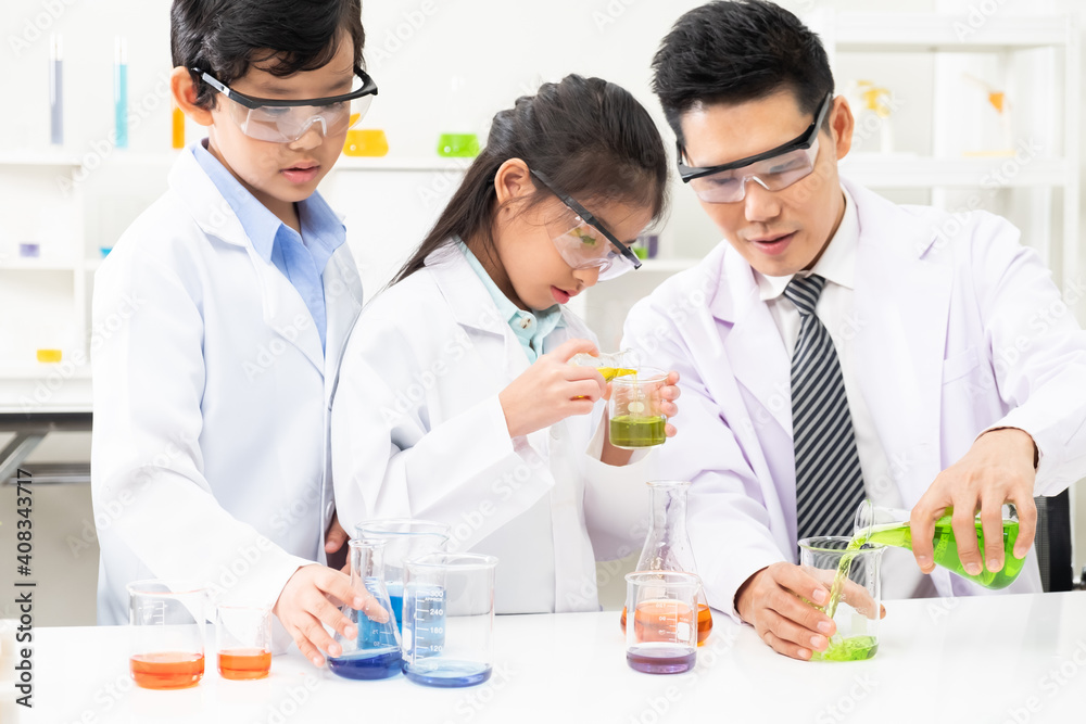 Young Asian kids wearing white scientist gown and do chemical test tube while study, learning in science classroom with teacher. Young children education concept by experiment, fun and enjoy classroom Young Asian kids wearing white scientist gown and do chemical test tube while study, learning in science classroom with teacher. Young children education concept by experiment, fun and enjoy classroom