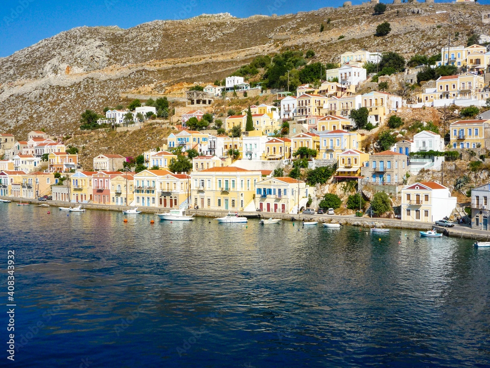 houses, buildings and castle with yachts and boats in the  port town of Simi a Greek island in the Aegean