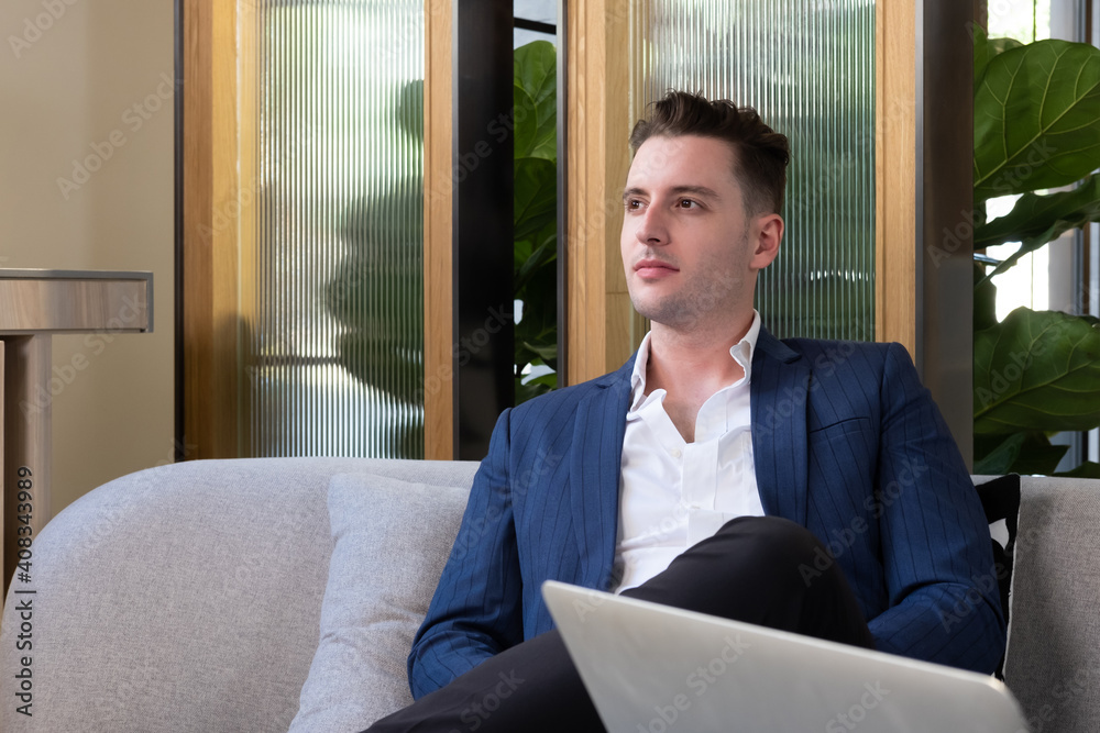Adult Caucasian businessman dress in smart formal suit sitting inside modern office space drinking coffee while waiting and planning for business meeting. Entrepreneur concept with copy space. Adult Caucasian businessman dress in smart formal suit sitting inside modern office space drinking coffee while waiting and planning for business meeting. Entrepreneur concept with copy space.