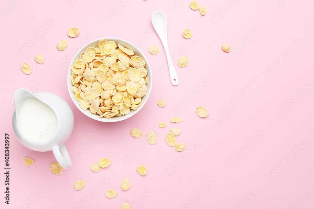 Corn flakes with milk in jar and spoon on pink background Corn flakes with milk in jar and spoon on pink background