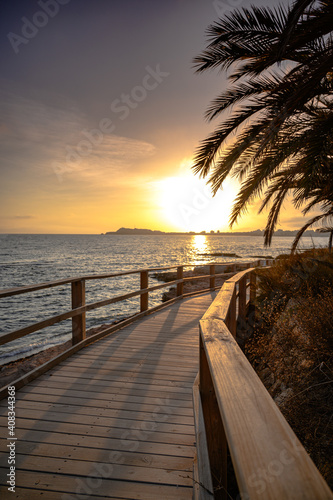 Atardecer en el mar  desde un puente de madera con palmeras