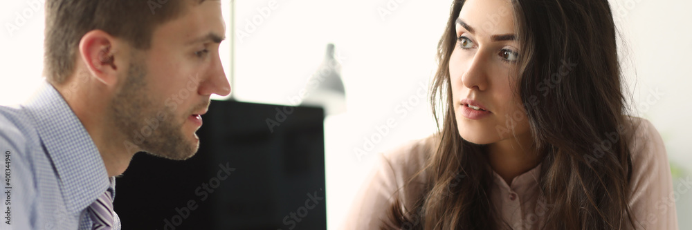 Fototapeta premium Man discussing something with his female coworker while staying at office. Teamwork and partnership concept