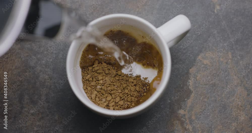Boiling water is poured in a cup with instant coffee, slow motion, macro top view. 300fps, Blackmagic Ursa Pro G2. Boiling water is poured in a cup with instant coffee, slow motion, macro top view. 300fps, Blackmagic Ursa Pro G2.