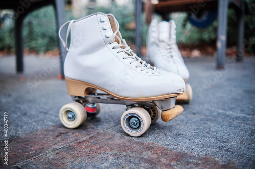 A pair of roller skates on the sidewalk.