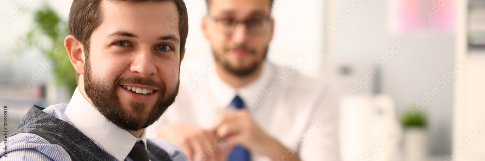 Portrait of smiling businessmen in shirts and ties sitting together during a meeting at the workplace. Work and business concept Portrait of smiling businessmen in shirts and ties sitting together during a meeting at the workplace. Work and business concept