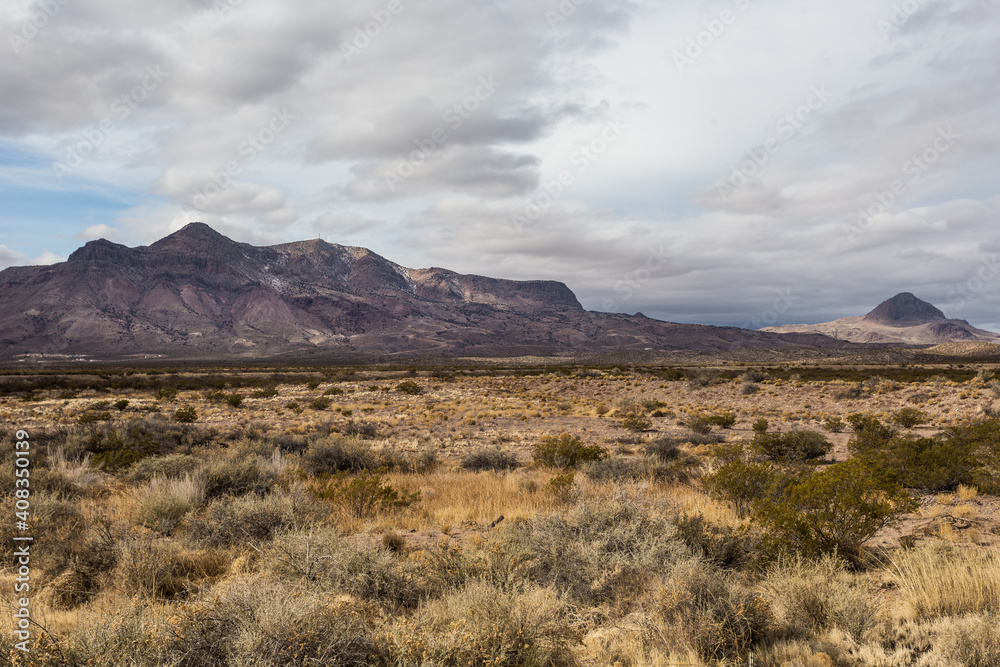 Stunning mountain range rising behind a vast desert vista landscape behind beautiful desert vista in rural New Mexico