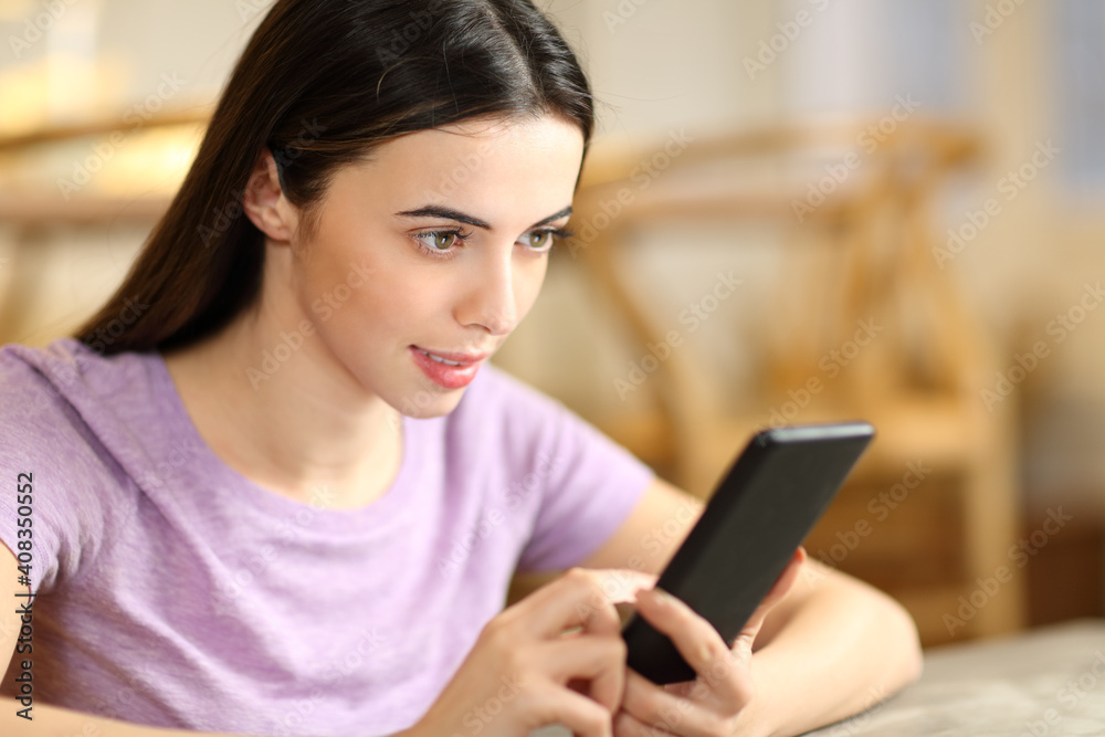 Woman checking content on smart phone at home Woman checking content on smart phone at home