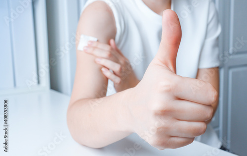 The girl after vaccination shows a gesture of approval with her hand.