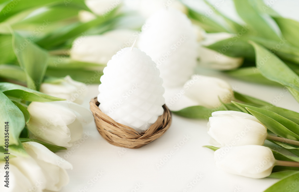 Easter candle egg and white tulips flowers on white background. Greeting card Easter candle egg and white tulips flowers on white background. Greeting card