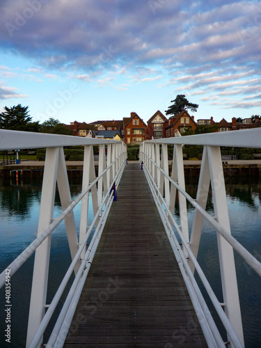 long steel metal and wood pontoon gangplank bridge across water to village