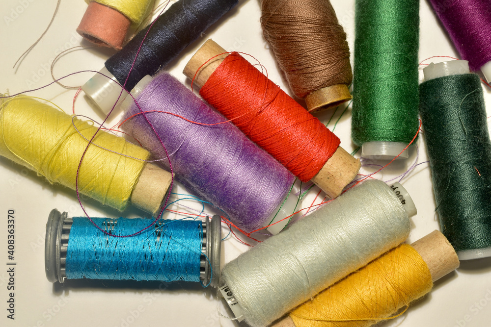 A set of spools with multi-colored threads on the table. A set of spools with multi-colored threads on the table.