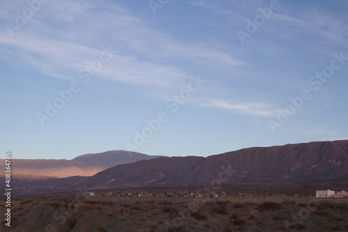 The beautiful arid mountains and desert at sunset. View of an ancient cemetery very high in the mountaintop in Cachi, Salta, Argentina.