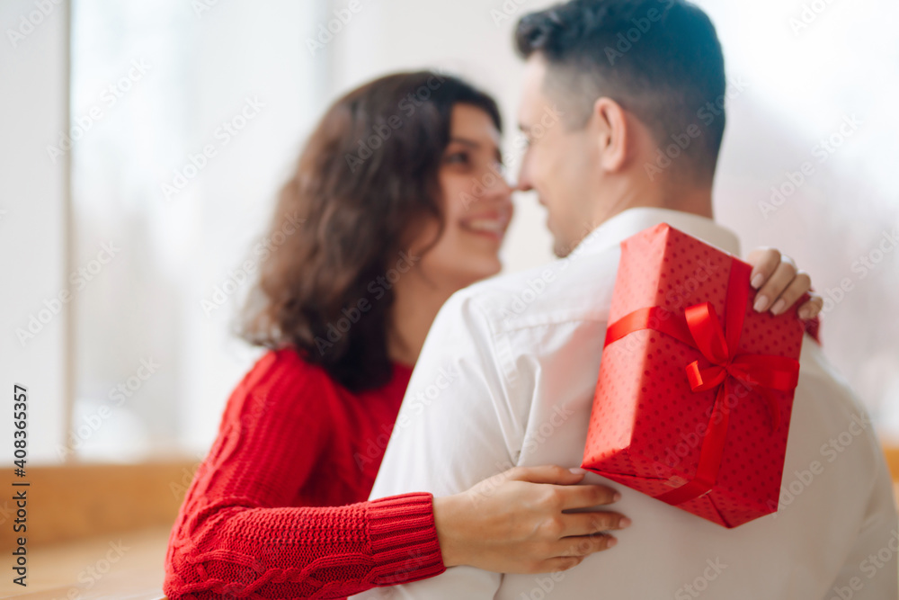 Young couple with gift box hugging and celebrating Valentine's Day. Relationship, holiday, surprise and love concept. Young couple with gift box hugging and celebrating Valentine's Day. Relationship, holiday, surprise and love concept.