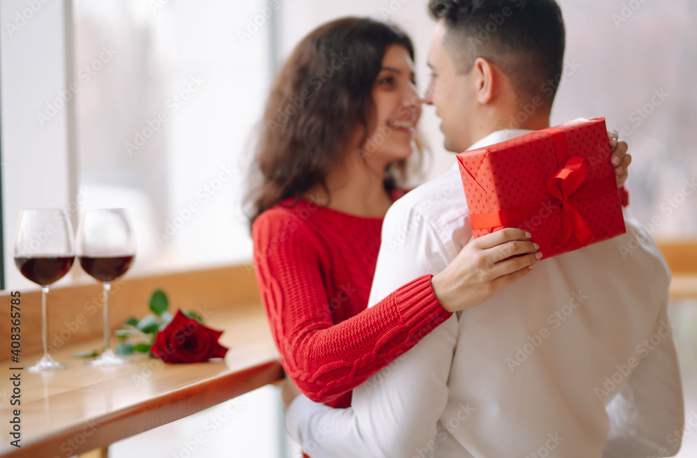 Young couple with gift box hugging and celebrating Valentine's Day. Relationship, holiday, surprise and love concept. Young couple with gift box hugging and celebrating Valentine's Day. Relationship, holiday, surprise and love concept.