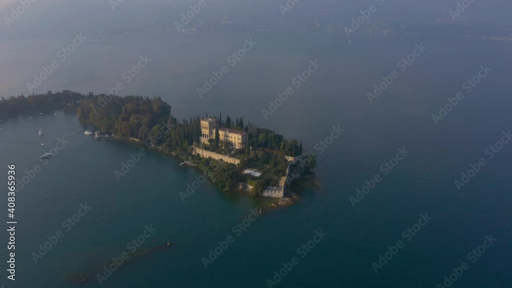 Pan left aerial shot of the entire Isola del Garda island located in famous Lake Garda Pan left aerial shot of the entire Isola del Garda island located in famous Lake Garda