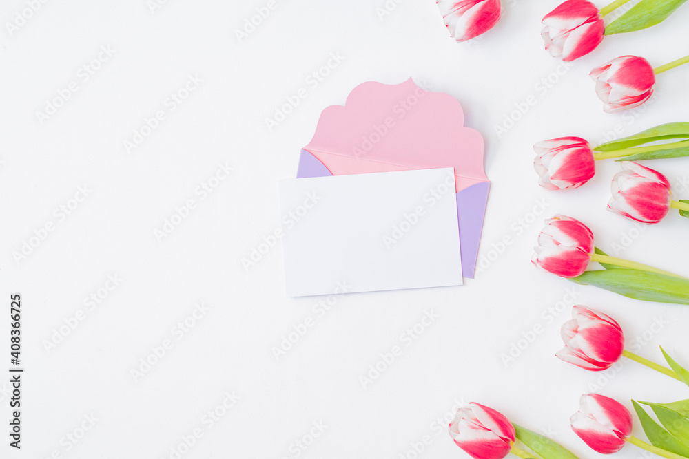 Mockup white greeting card and envelope with pink tulips on a white background