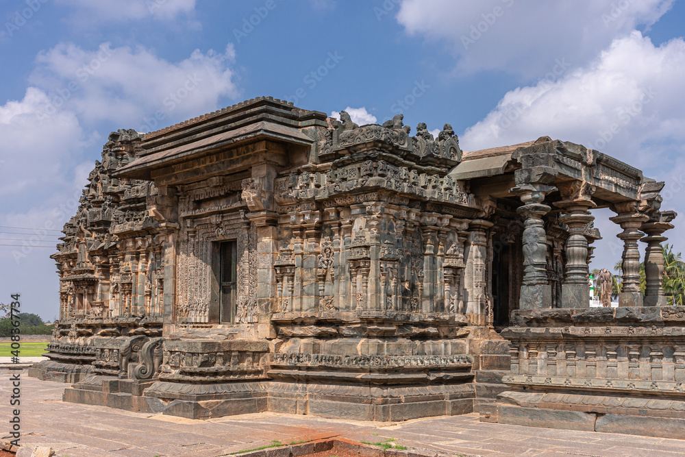Lakkundi, Karnataka, India - November 6, 2013: DArk stone Kasivisvesvara Temple Sanctum in closeup under blue cloudscape.