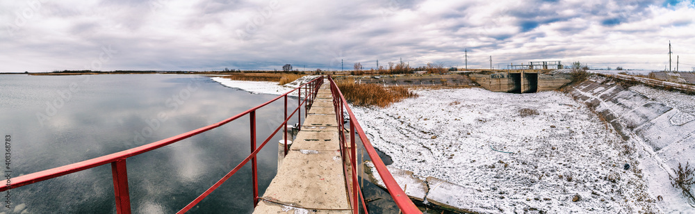 bridge along the reservoir next to the road in winter, technical structures bridge along the reservoir next to the road in winter, technical structures