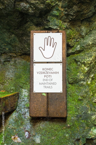 A sign warns walkers that the maintained walking trails have ended along the banks of the Tolminka River which flows through Tolmin Gorge in the Triglav National Park, north western Slovenia 