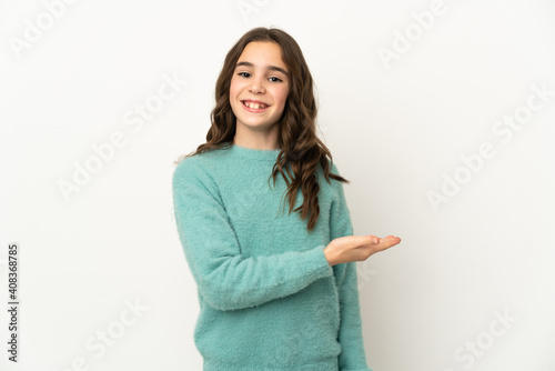 Little caucasian girl isolated on white background presenting an idea while looking smiling towards