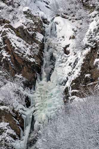 beautiful frozen waterfalls with fresh snow on a cold winter day