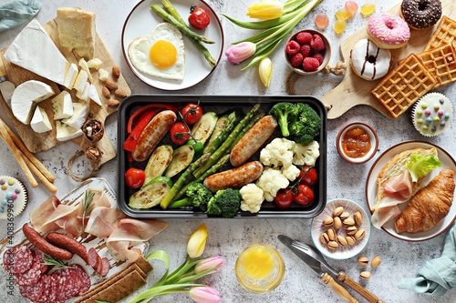 Breakfast food table. Festive brunch set, meal variety with grill platter, fried egg, croissant sandwich, cheese platter and desserts. Overhead view