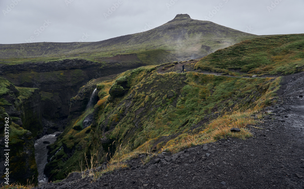 Mountain route around a cliff and a river. Skogafoss waterfall Mountain route around a cliff and a river. Skogafoss waterfall
