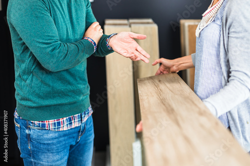 Man choosing parquet in store for his home.