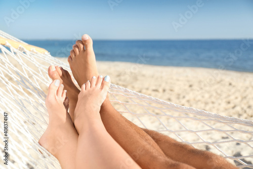 Couple relaxing in hammock on beach, closeup