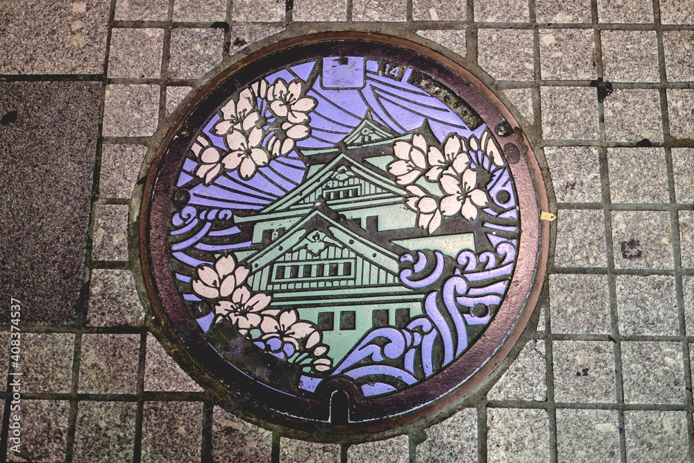 Osaka traditional sewer cover (manhole) with beautiful design of Osaka Castle, waves and sakura flowers