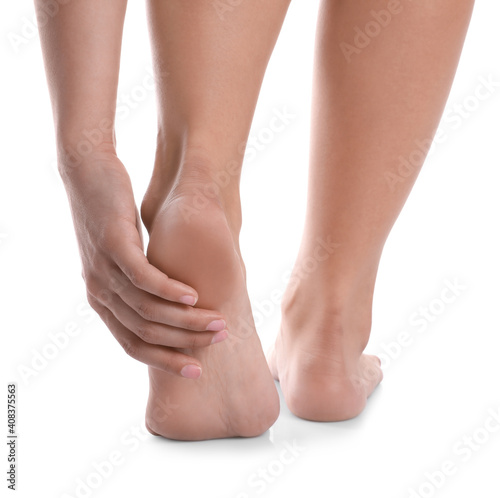 Young woman suffering from pain in foot on white background, closeup © New Africa
