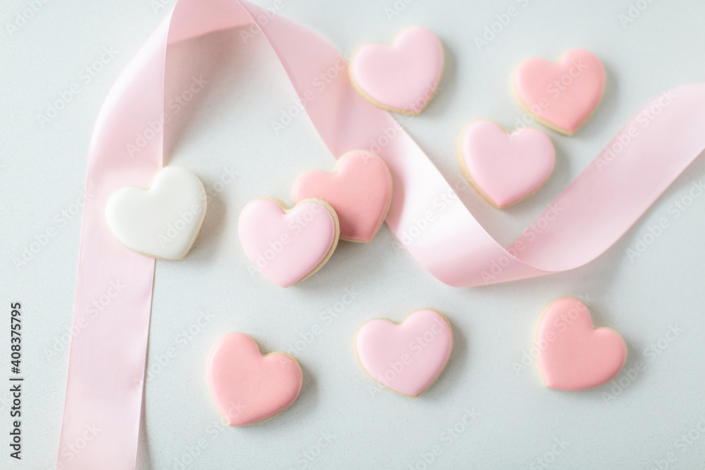 pink heart sugar cookies on white background with pink ribbon