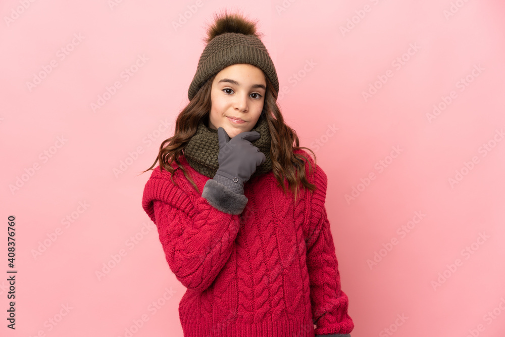 Little girl with winter hat isolated on pink background thinking Little girl with winter hat isolated on pink background thinking