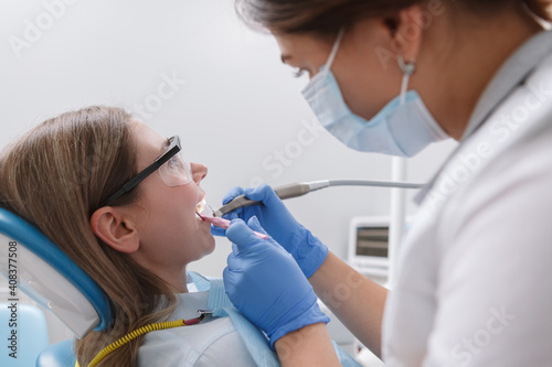 Close up of a professional dentist at work, treating teeth of patient