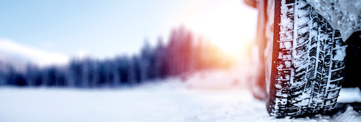 Winter tire. Detail of car tires in winter on the road covered with snow. Panorama, banner..