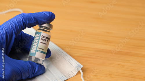 Doctor, nurse hand in blue gloves holding coronavirus covid-19 vaccine